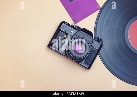 An old vinyl record, a film camera and a floppy disc for a computer are reminders of the rapid progress in the field of high technologies Stock Photo