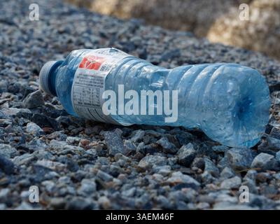 Empty plastic water bottle laying on the ground Stock Photo
