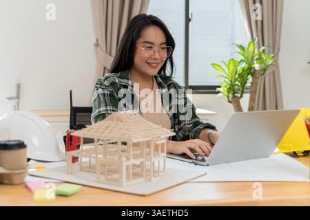 Data working and tablet laptop. Architect explaining project plan to clients. Confident businesswoman holding architectural model in office. Stock Photo