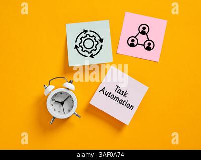 Sticky notes representing task automation, teamwork and process optimization, along with an alarm clock, symbolizing time management and efficiency Stock Photo