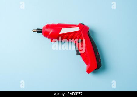Top view of red cordless mini screwdriver on blue background Stock Photo
