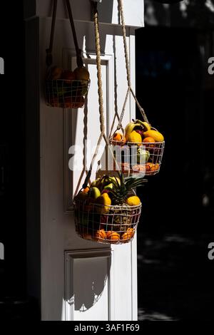 Aesthetic composition of fresh fruits in hanging wire baskets. This image is perfect for food-related content, healthy lifestyle concepts or organic m Stock Photo
