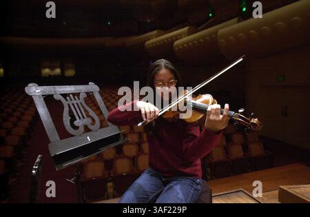 Oct 13, 2001; San Francisco, CA, USA; Fourteen-year-old violinist Hanako Hjersman (cq) tunes up before a San Francisco Youth Orchestra rehearsal at Davies Symphony Hall in San Francisco Saturday. The Walnut Creek girl has been playing the violin since she was 4. Stock Photo