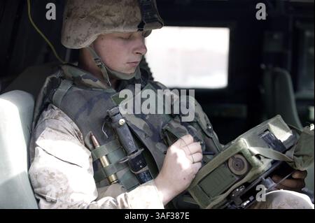 Jan 04, 2005; Camp Fallujah, Iraq; Lance Cpl. ROBERT C. HAMPSTEN, 21, a native of Seattle, and a radio operator with Headquarters Company, Regimental Combat Team 1 Communication, works with a mounted data automated communications terminal (M-DACT), a small tactical green laptop, which connects to an enhance position location reporting system for wireless Internet and also acts as a pin point global positioning system, at Camp Fallujah, Iraq Jan 4. Through the wireless Internet the M-DACT can access the secured Internet protocol router network to communicate with other Marines while on convoys Stock Photo