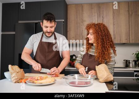 Chefs preparing chicken and red meat in modern kitchen Stock Photo