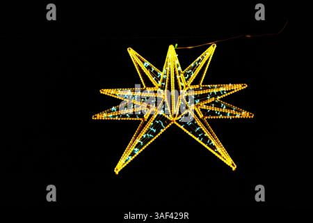 Illuminating the night, a magnificent starburst of golden and teal LED lights. Geometric star, crafted from glowing LED lights, creating a striking Stock Photo