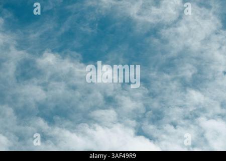 whispy white clouds against blue sky Stock Photo