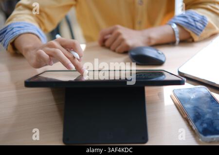 Male web designer drawing with graphic tablet at table in office. Stock Photo