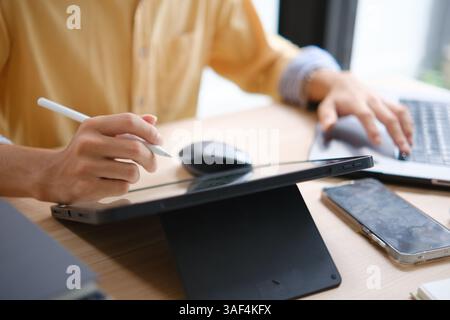 Male web designer drawing with graphic tablet at table in office. Stock Photo