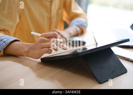 Male web designer drawing with graphic tablet at table in office. Stock Photo
