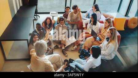 Undergrad students gathered in a friendly environment, actively engaged in a group discussion and teamwork activity. Stock Photo