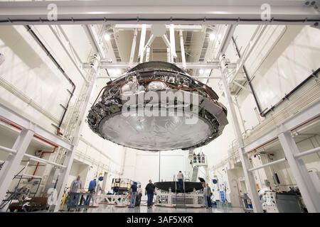 Mar 10, 2015 - Kennedy Space Center, Florida, U.S. - Engineers across the country have been busy taking a closer look at NASA's Orion spacecraft and the data it produced during its successful flight test in December 2014. Inside the Launch Abort System Facility at NASA's Kennedy Space Center in Florida, Orion is lifted using a special crane for removal of its heat shield on Feb. 13, 2015. In the background, technicians move the heat shield on a work stand. Removing the back shell allows a closer look at Orion's systems to see how they fared during the trip to space. The heat shield was removed Stock Photo