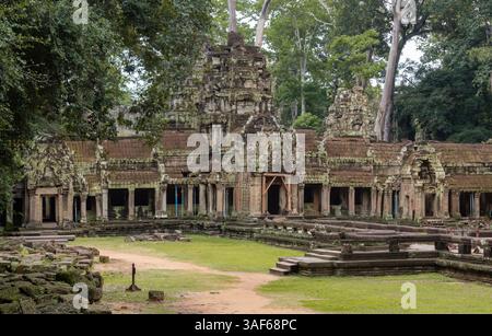 Moss-covered green stone building structure exterior and bricks at Ta Prohm Tomb Raider temple complex in the lush green forest. Angkor Wat historical Stock Photo