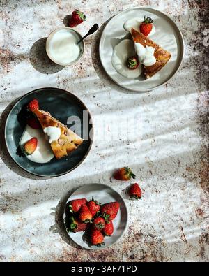 Top view, flat lay of two slices of strawberry short cake decorated with fresh strawberries and cream on a rustic background Stock Photo