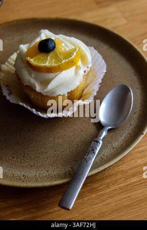 Lemon cupcake on a brown  serving plate with vintage spoon Stock Photo
