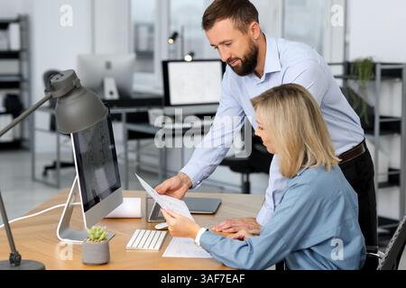 Technicians making digital engineering drawing on computer at desk in office Stock Photo