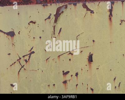 painted yellow sheet metal with scratches and rust as background texture, graphic resource of old rusty scratched surface with abstract traces Stock Photo