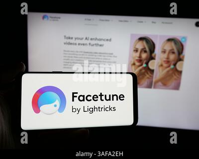 Stuttgart, Germany - 11-20-2024: Person holding smartphone with logo of photo editing app Facetune (Lightricks) on screen in front of website. Stock Photo