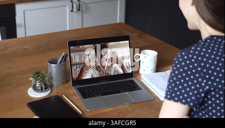 Woman participating in webinar or video call with Indian man Stock Photo