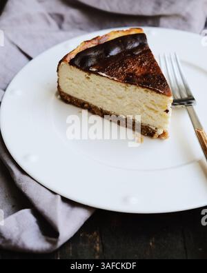 Slice of New York style baked cheesecake on a white plate Stock Photo