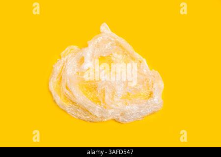 Waste from a plastic wrapper on a yellow background Stock Photo
