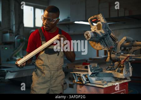 Carpenter Examining Wooden Detail In Factory Stock Photo