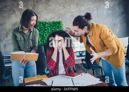 Young professionals engaged in lively discussion at a modern office workspace, emphasizing teamwork Stock Photo