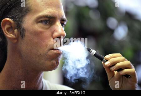 Tyler Bush, manager of The Vapor Bar in Grapevine, Texas, puffs on an  electronic cigarette. 