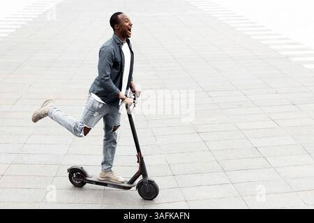 Guy having pleasant ride on electric kick scooter Stock Photo