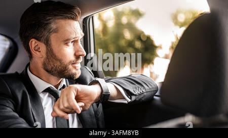 Handsome bearded man in suit sitting in car Stock Photo
