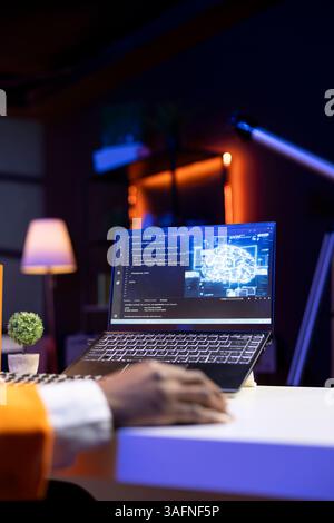 AI expert writes code on laptop in apartment office using Java programming languages. Artificial intelligence programmer remotely working on fixing database errors while working from home, close up Stock Photo