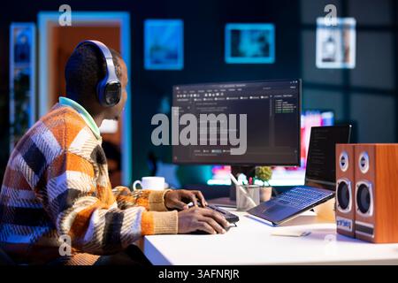 Male programmer working on developing new html script, typing binary code on terminal window. Young web developer does debugging work with coding language, database internet security. Stock Photo