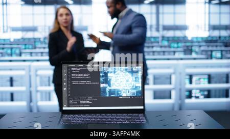 Laptop in data center establishment with artificial intelligence computing simulating human brain. Close up shot of notebook displaying AI machine learning algorithms, camera B Stock Photo