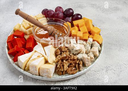 Appetizer, assorted cheese, with nuts and honey, on a round plate, top view, no people Stock Photo