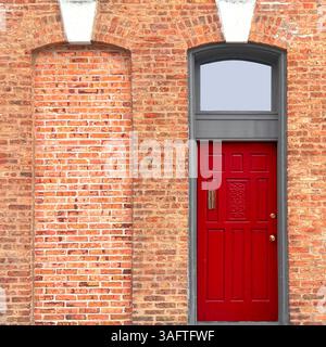 An ornate red Chicago entryway with detailed white stone trim and fanlight-style arch window radiates historic charm and symmetry Stock Photo