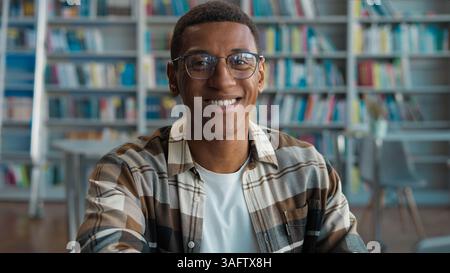 African American man guy male typing browsing laptop online computer high school library university student studying learning e-learning looking at Stock Photo