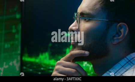 Arabian Indian man programmer businessman currency crypto thoughtful doubtful office computer hacker broker thinking trader male trading analysis Stock Photo