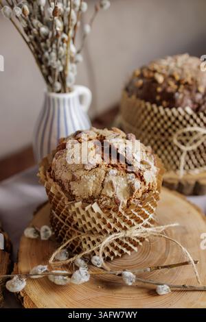 Traditional Easter cake decorated with almonds and icing, set on rustic wood with willow branches and spring decor. Stock Photo