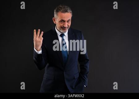 Mature businessman in a suit holding up three fingers, suggesting countdown, listing Stock Photo