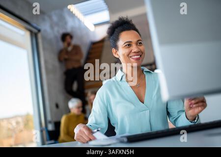 Black woman working in office and futuristic graphical user interface concept. System engineering. Stock Photo