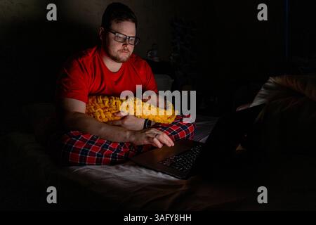Father Holding Baby While Using Laptop in Dim Light Stock Photo