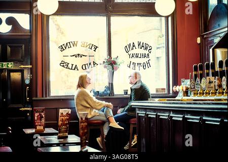 Couple enjoying a drink in the Swan and Railway pub in Wigan town Centre,uk Stock Photo