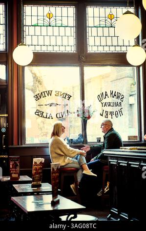 Couple enjoying a drink in the Swan and Railway pub in Wigan town Centre,uk Stock Photo