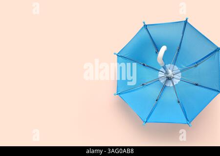 Mini stylish umbrella on beige background Stock Photo