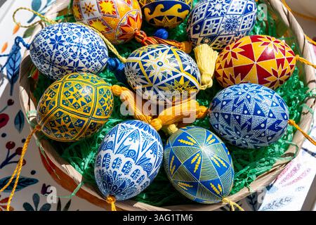 A woven basket brimming with beautifully crafted Easter eggs featuring vibrant Ukrainian pysanky designs, showcasing intricate patterns that celebrate Stock Photo