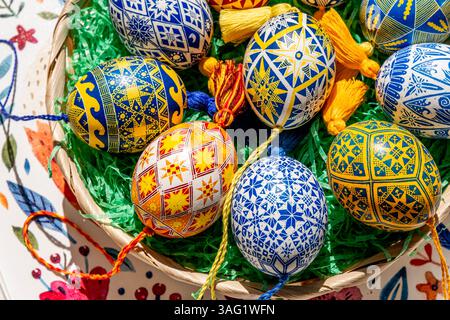 Brightly colored Easter eggs are artistically arranged in an Easter basket, showcasing traditional Ukrainian pysanky adorned with elaborate folk patte Stock Photo