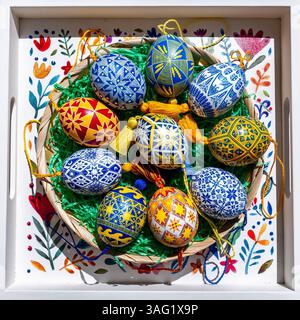 Colorful Easter eggs filled with traditional Ukrainian pysanky designs are placed in a beautifully decorated basket, representing spring festivities a Stock Photo
