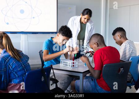 In school, students conducting science experiments with test tubes and microscope Stock Photo