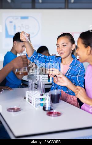Conducting science experiment with test tubes, students in high school ...