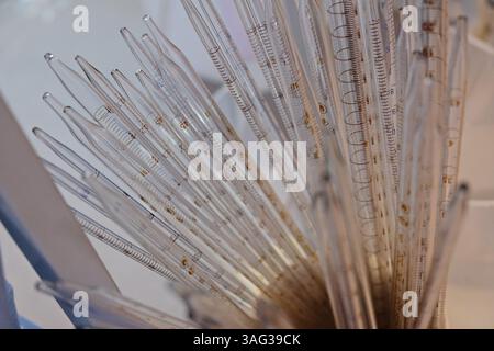 Pipette flasks for sampling various types of liquids for laboratory analysis under a microscope Stock Photo